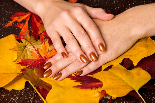 Hands with bronze polish on nails