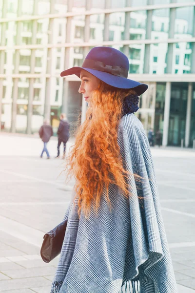 Red headed woman wearing poncho