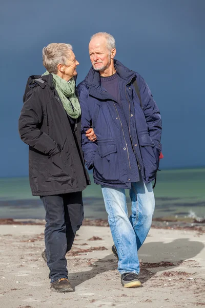 Happy  senior couple walking on beach