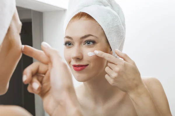 Woman Applying Cream on Face