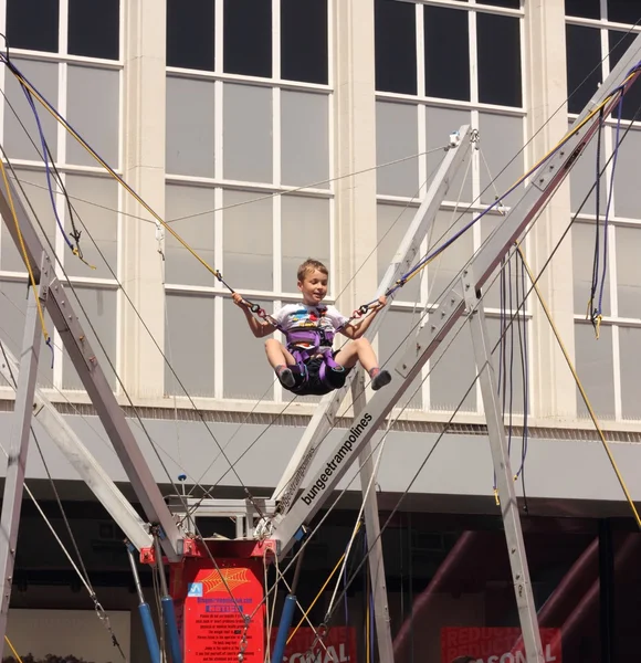 A young boy having fun on a bungee trampoline