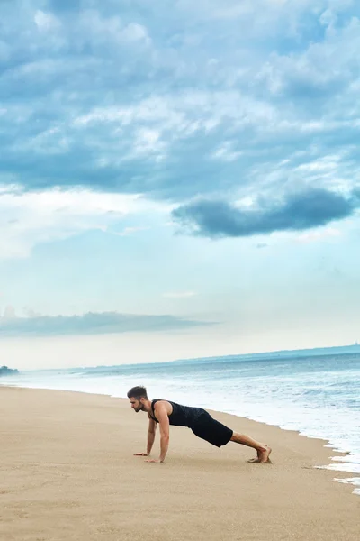 Man Doing Push Up Exercise On Beach. Body Exercising Concept