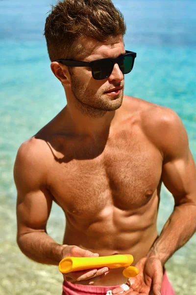 Summer Skincare. Man Applying Sunscreen Protection Body Lotion