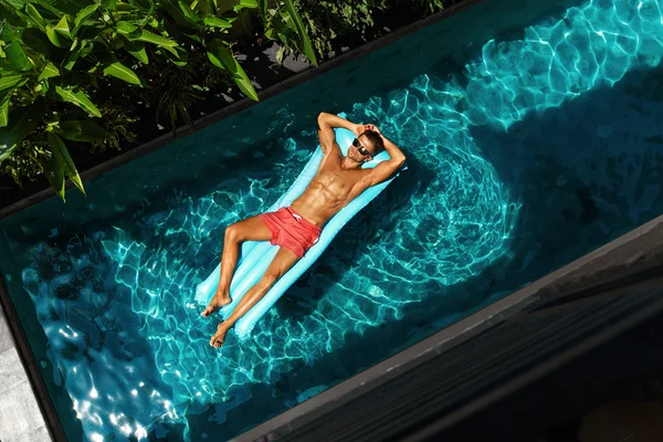 Man On Summer Vacation. Male Model Tanning In Swimming Pool