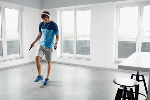 Sport Fitness Workout. Healthy Man Skipping Jump Rope Indoors.