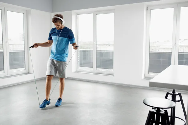 Sport Fitness Workout. Healthy Man Skipping Jump Rope Indoors.