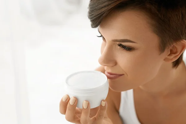 Skin Care. Beautiful Happy Woman Holding Face Cream Lotion