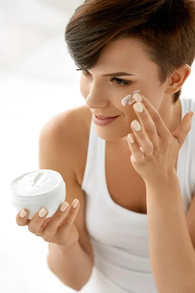 Beauty Skin Care. Beautiful Woman Applying Cosmetic Face Cream
