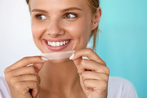 Woman With Healthy White Teeth Using Teeth Whitening Strip