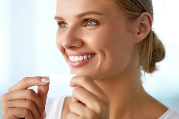 Woman With Healthy White Teeth Using Teeth Whitening Strip