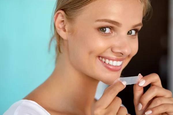 Woman With Healthy White Teeth Using Teeth Whitening Strip