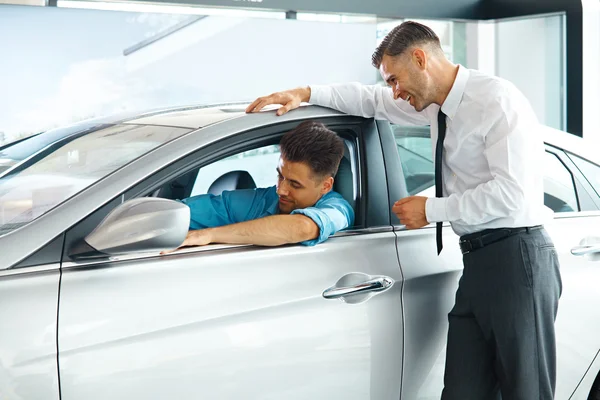 Car Sales Consultant Showing a New Car to a Potential Buyer