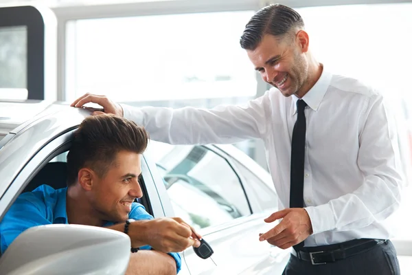Car Salesman Handing over new Car Key to Customer