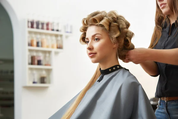 Hairdresser doing hairstyle for woman