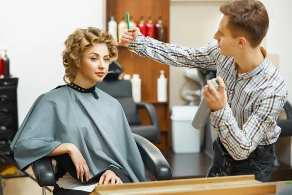 Hairdresser doing hairstyle for  woman