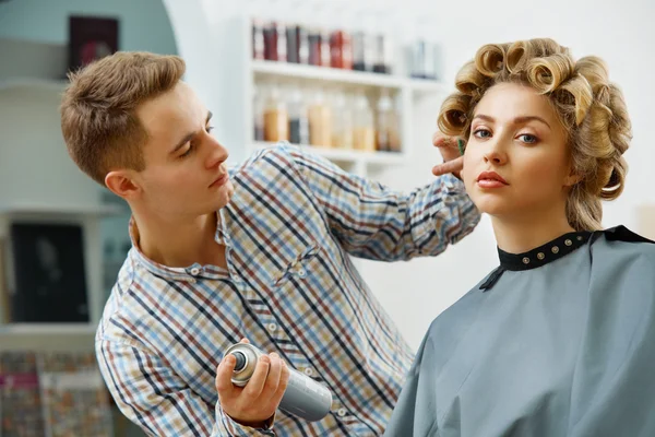 Hairdresser doing hairstyle for  woman