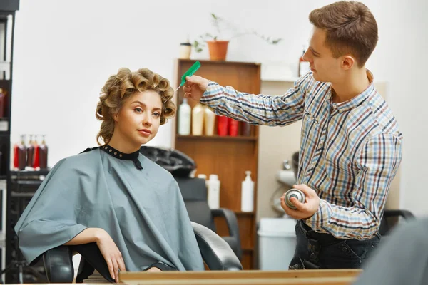 Hairdresser doing hairstyle for  woman