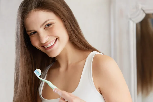 Beautiful woman with toothbrush. Dental care background.