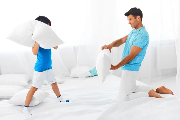 Dad and son having fun. Pillow fight.