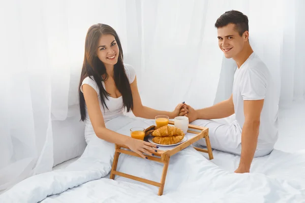 Husband serving wife breakfast in bed