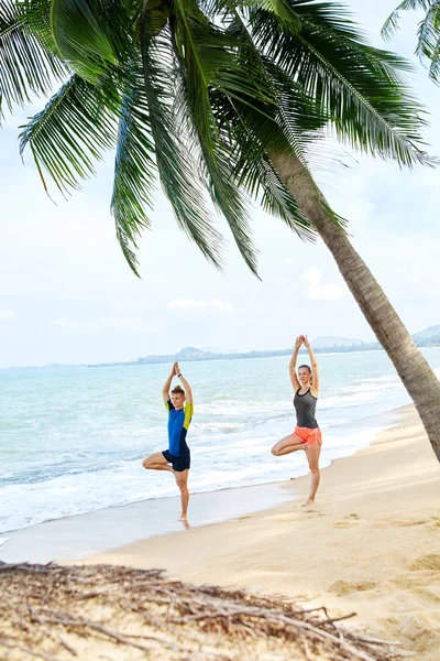 Fitness. Couple Practicing Yoga On Beach. Exercising. Sports. St