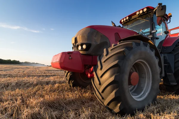Agriculture tractor on a  stubble field