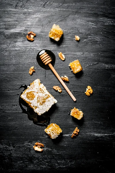 Honey background. Natural honey comb and a wooden spoon .