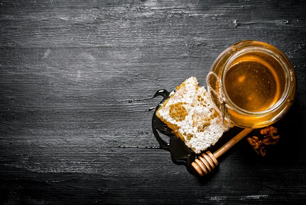 Honey background. Natural honey comb and a glass jar.