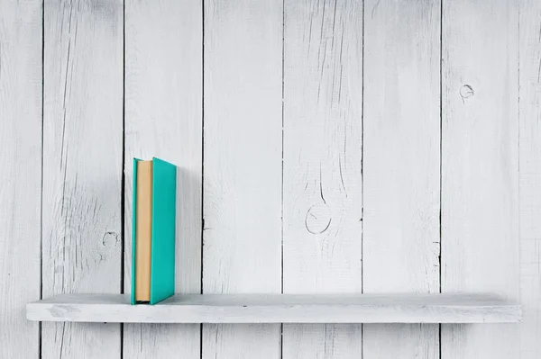 Book on a wooden shelf.