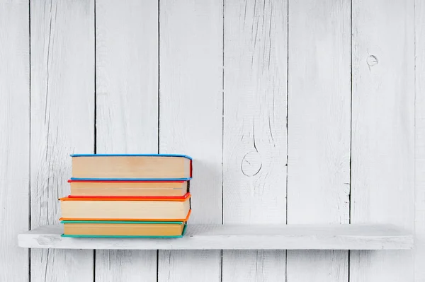 Books on a wooden shelf.