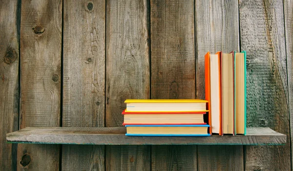 Books on a wooden shelf.