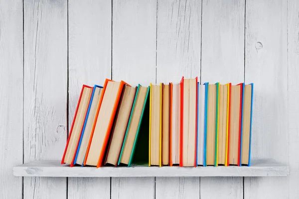 Books on a wooden shelf.