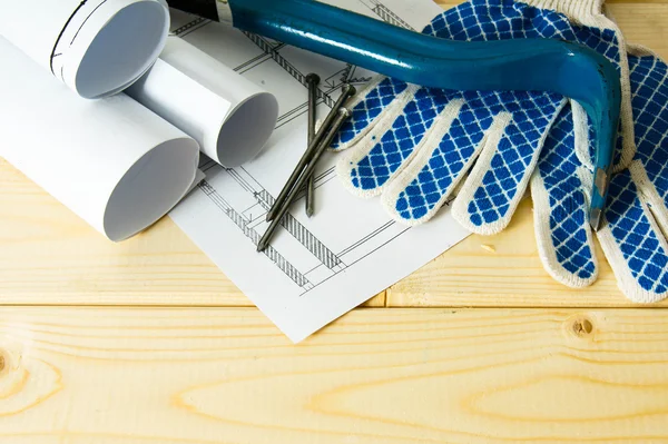 Repair work. Drawings for building, mount and gloves on wooden background.