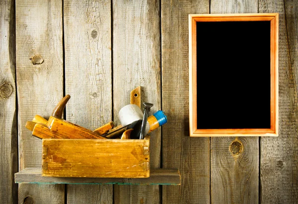 Many old tools and frame on a wooden background.