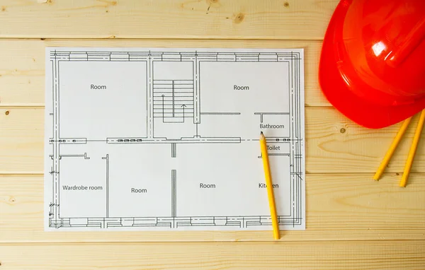 Repair work. Drawings for building, helmet, pencils on wooden background.