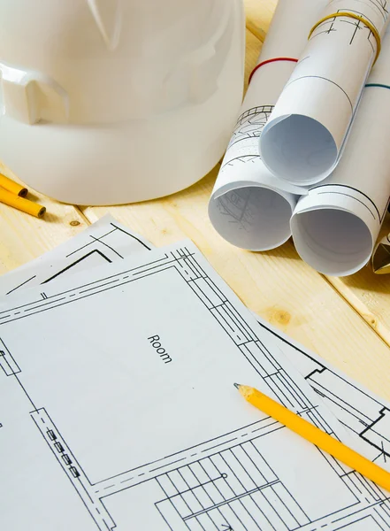 House construction. Drawings for building, helmet and others tools on wooden background.