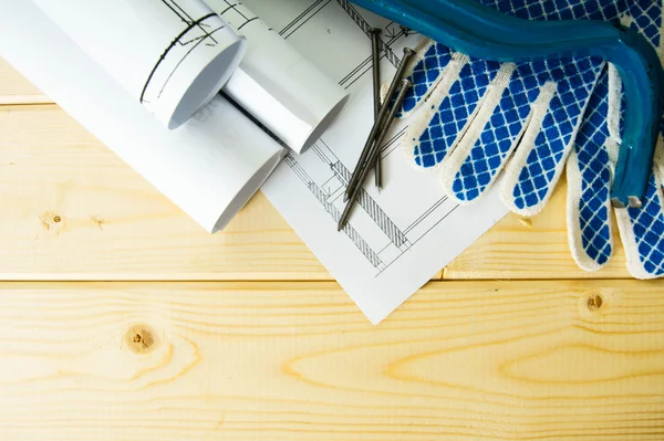 Repair work. Drawings for building, mount and gloves on wooden background.