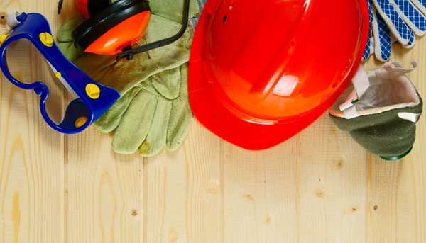 Helmet, ear-phones, glasses protective and other tool on a wooden background.