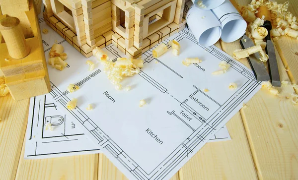 Joiners works. Drawings for building, small house and working tools on wooden background.