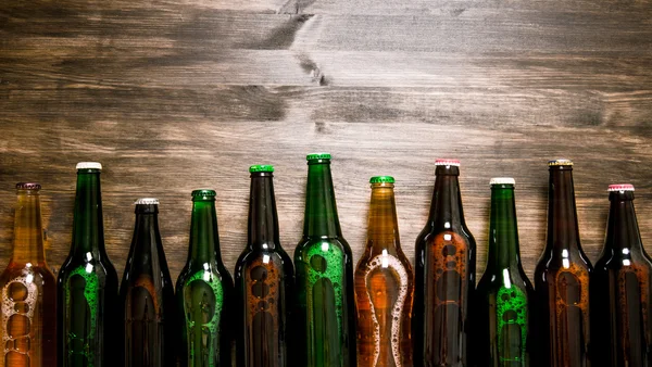 Beer bottles on wooden table .