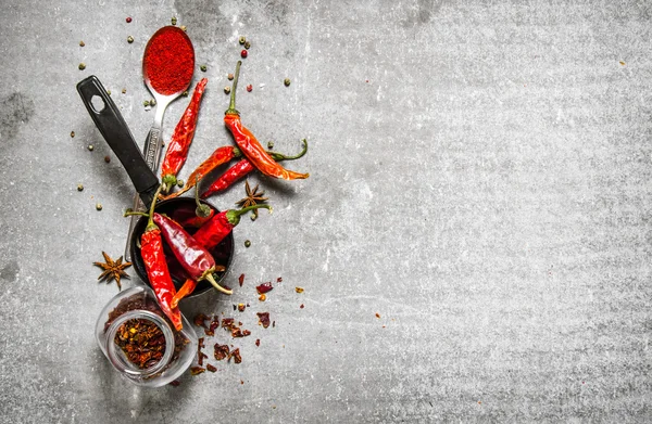 Dried peppers in jar. On stone background.