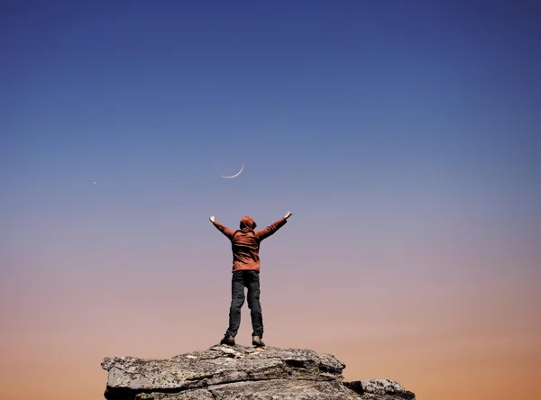 Man standing on the top of the mountain over night sky