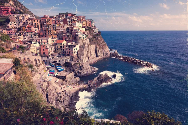 Retro style photo of Manarola town at sunny day