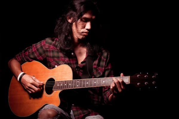 Long hair guy playing guitar acoustic