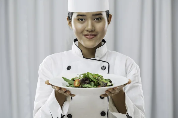 Chef holding a plate of salad