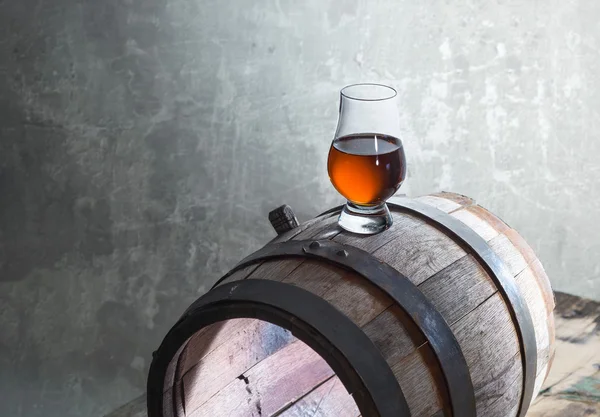 Glass of whiskey on a old barrel
