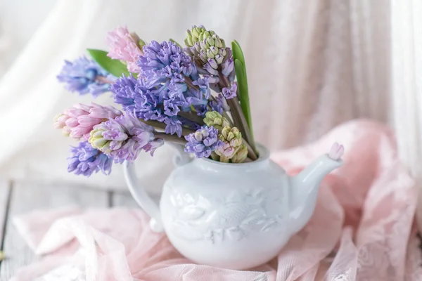 White teapot with bouquet of hyacinth