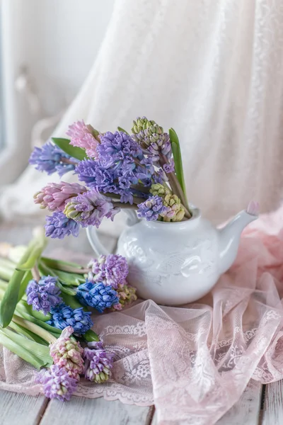 White teapot with bouquet of hyacinth