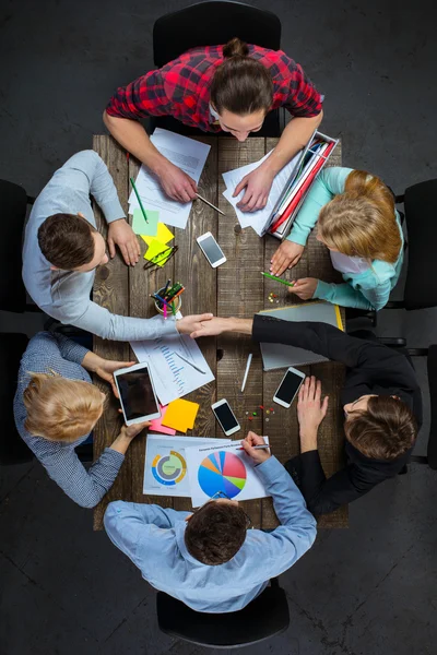 Top view of business people at wooden table