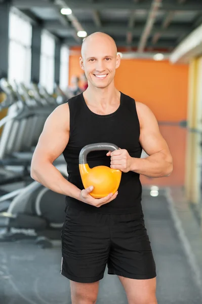 Man doing exercise with kettlebell in gym